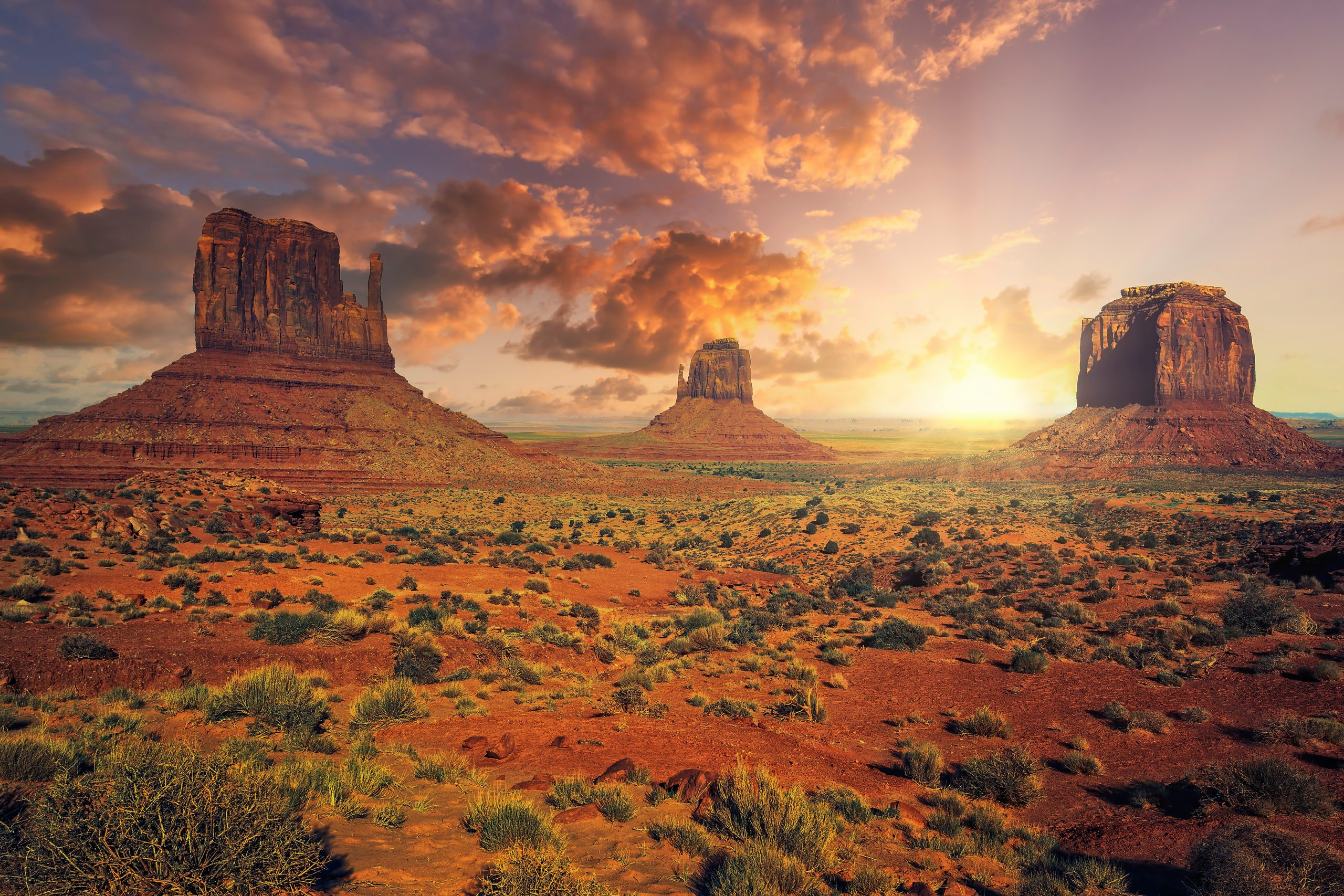 Red rock buttes across a desert valley at sunset