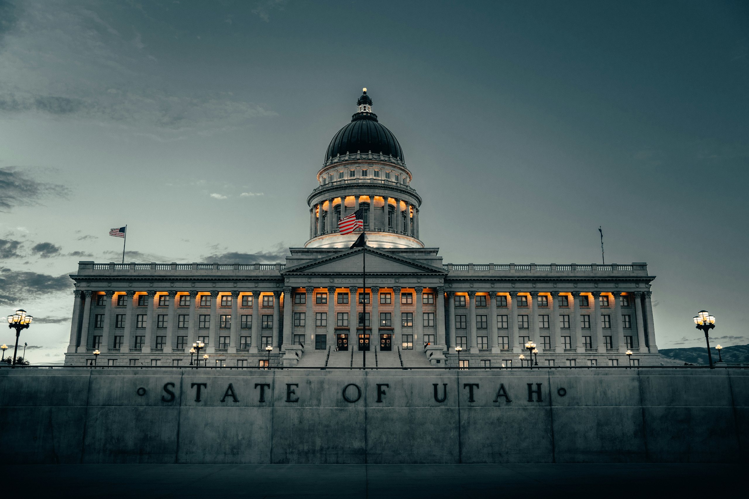 The Utah State Capitol at dusk, its dome and colonnade lit from within