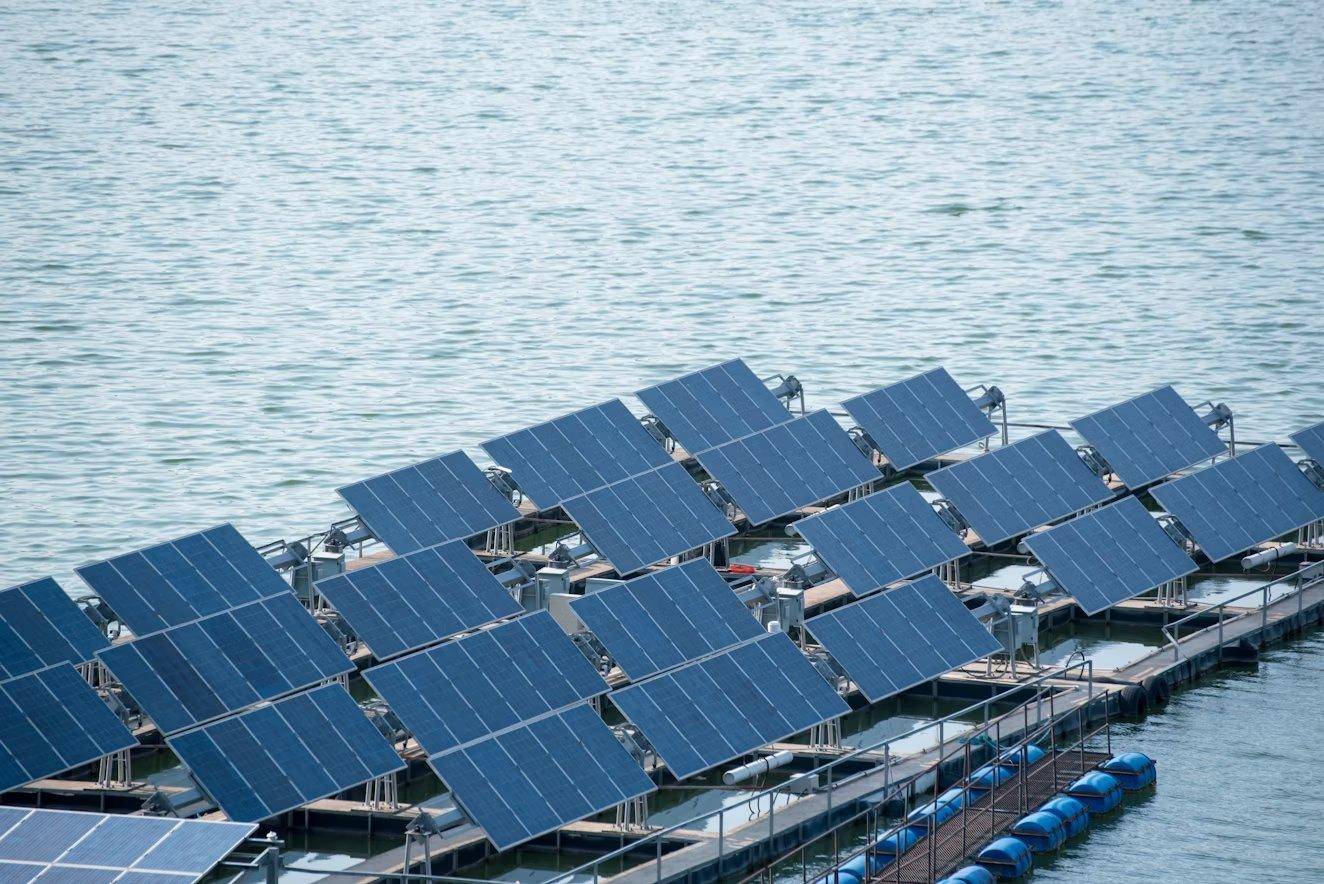Floating solar panels arranged in rows on a reservoir